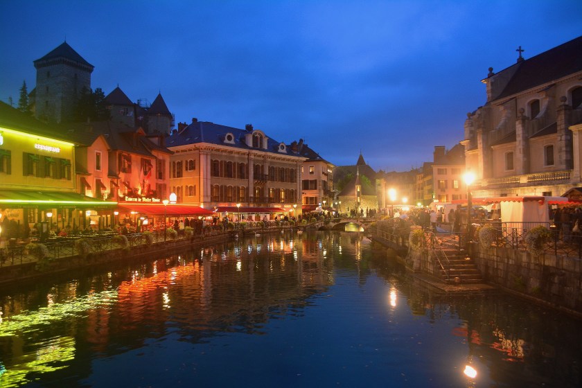 Beautiful Old town canal lined by Cafes and the Chateau in the background 